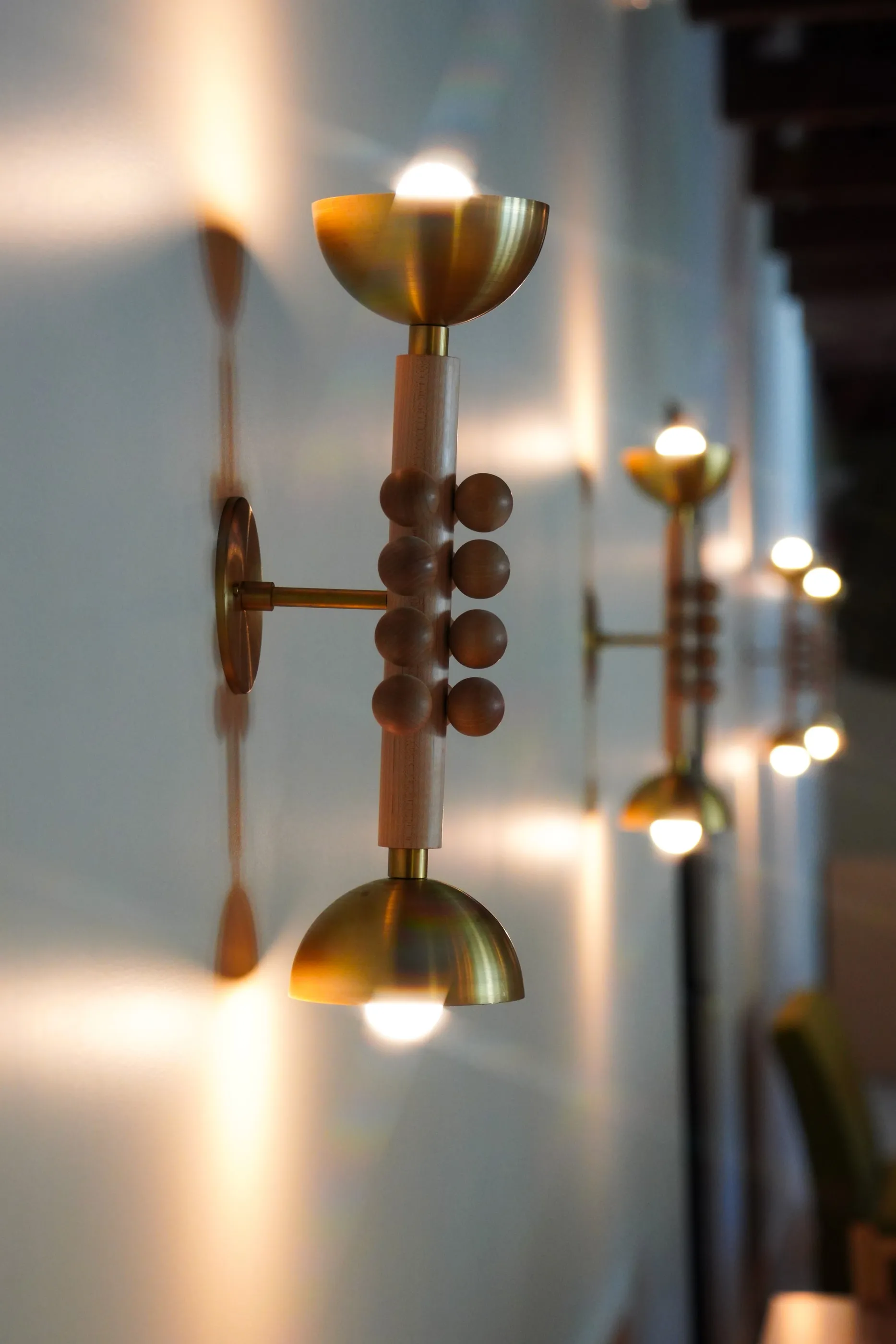 Brass and walnut sconces along the Rooted Restaurant wall
